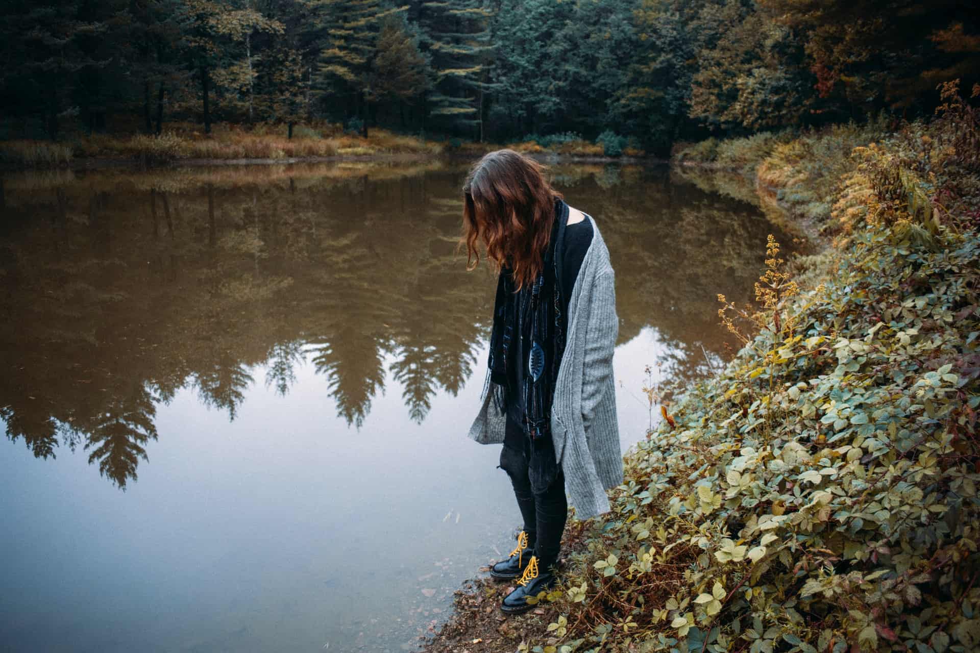 la femme se promène dans les bois au bord du lac