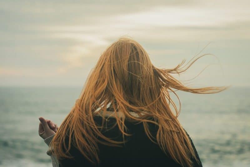 la femme se tient dos à la mer