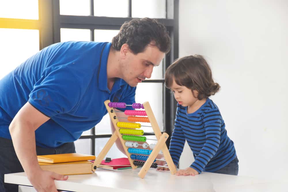 l'homme apprend à un enfant à utiliser l'abaque
