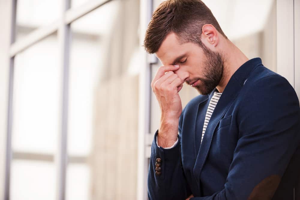 l'homme garde sa tête avec sa main et pense