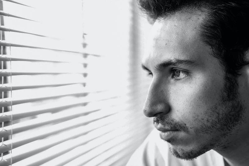 l'homme regarde pensivement par la fenêtre