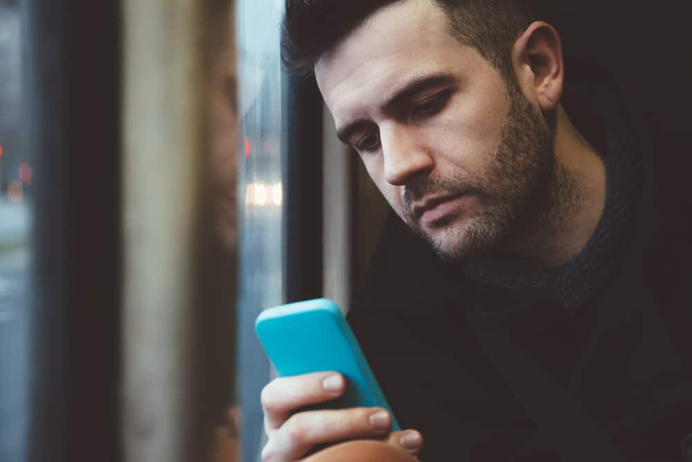 l'homme s'assoit et regarde le téléphone
