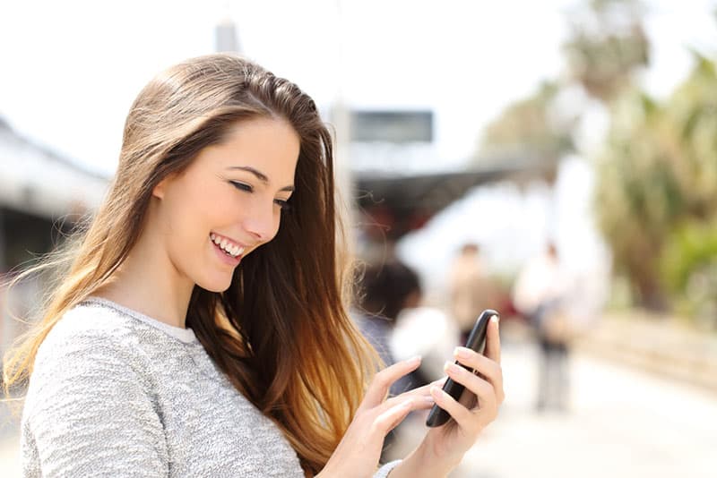 sourire, jeune femme, textos, téléphone