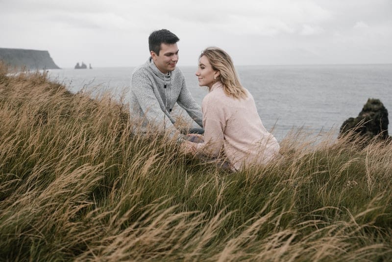un couple amoureux assis sur l'herbe près de la mer