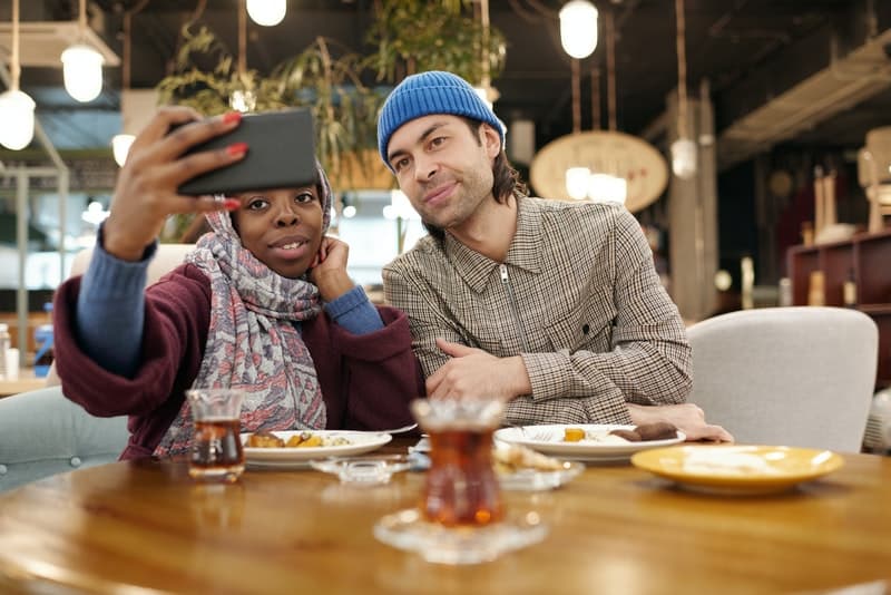 un couple amoureux lors d'un dîner dans un restaurant prend une photo de selfie