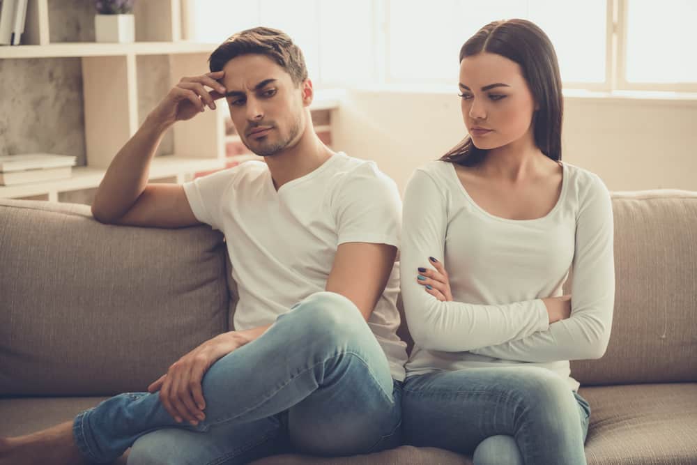 un couple d'amoureux en querelle est assis sur le canapé