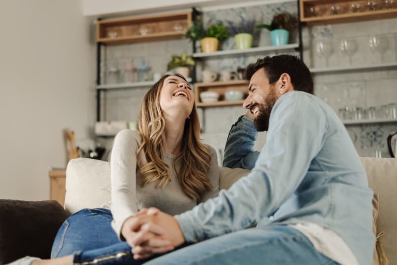 un couple s'amusant en parlant sur le canapé