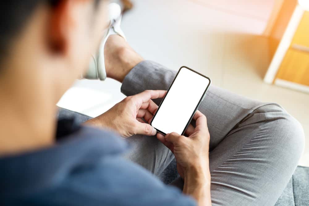 un homme appuie sur le téléphone et s'assied