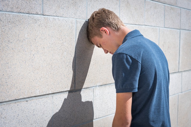 un homme appuyé contre un mur