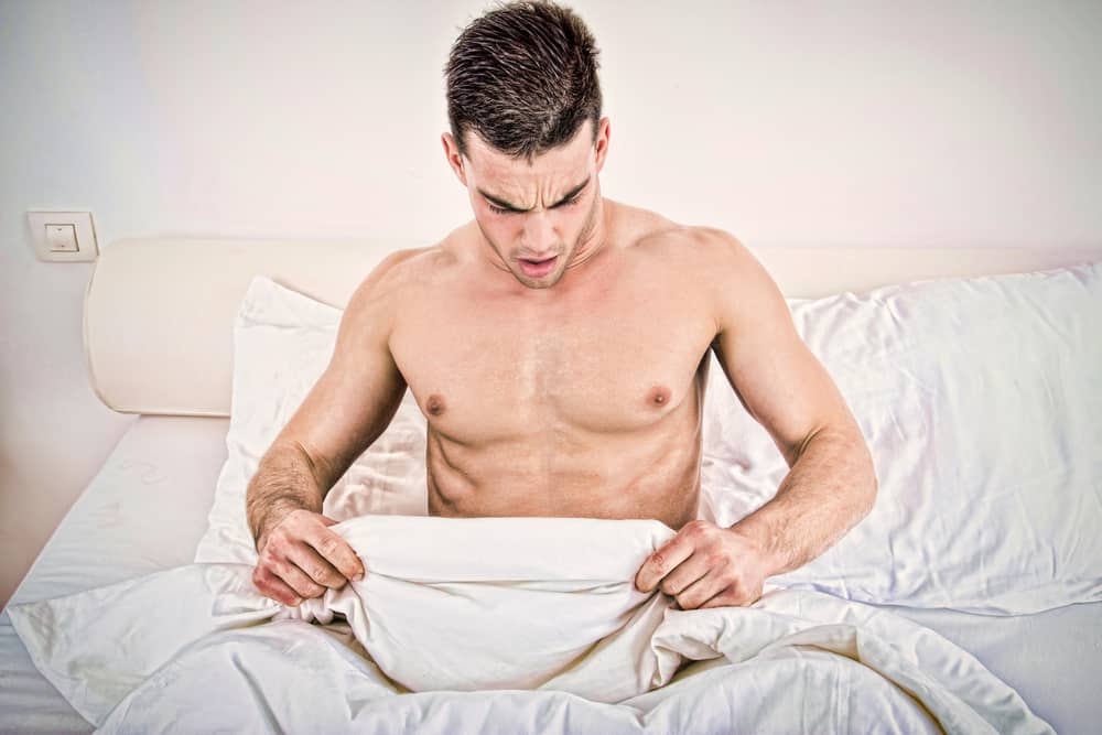 un homme au lit à la recherche sous une couette