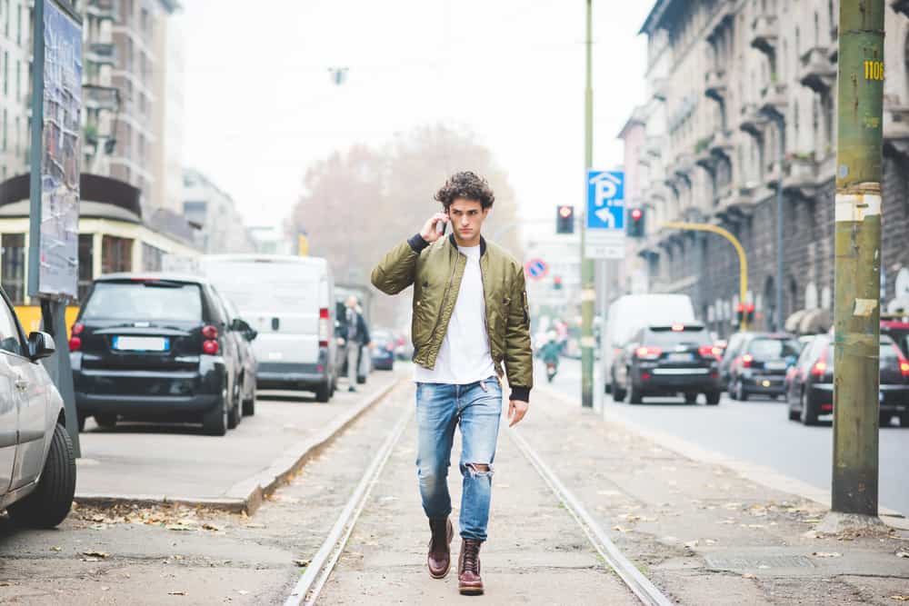 un homme avec un téléphone portable marche dans la rue