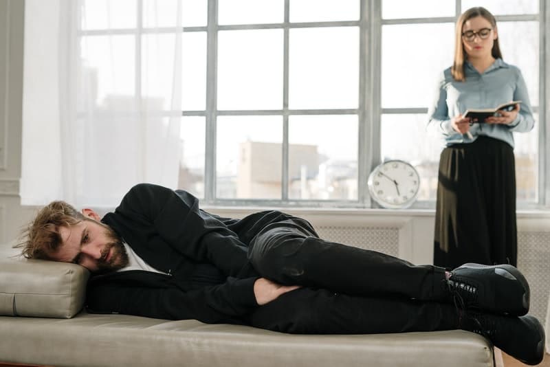 un homme déprimé est allongé pour parler à un psychologue