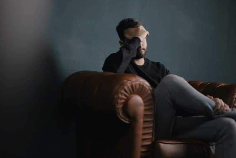 un homme déçu est assis sur le canapé