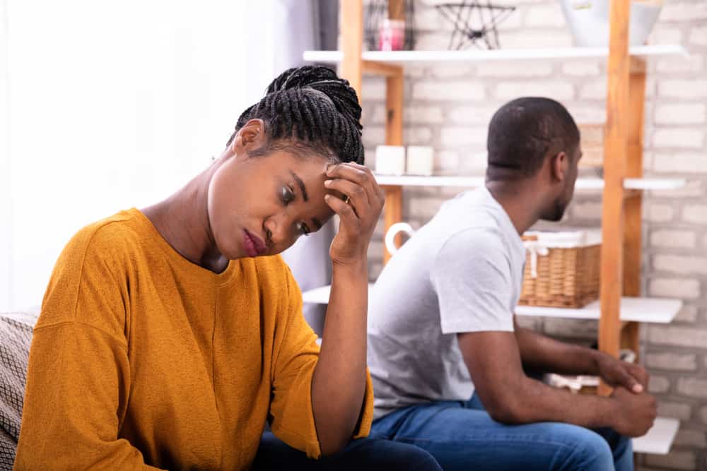 un homme et une femme assis sur le canapé en colère l'un contre l'autre