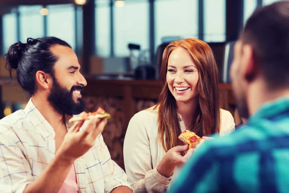 un homme et une femme avec un ami au dîner se regardent
