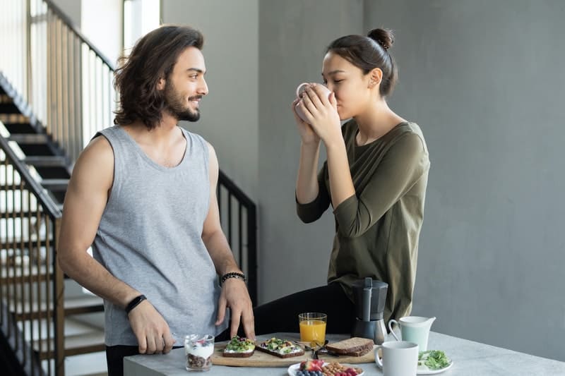 un homme et une femme dans la cuisine buvant du café
