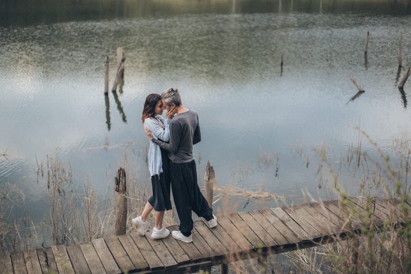 un homme et une femme embrassant à côté de la jetée