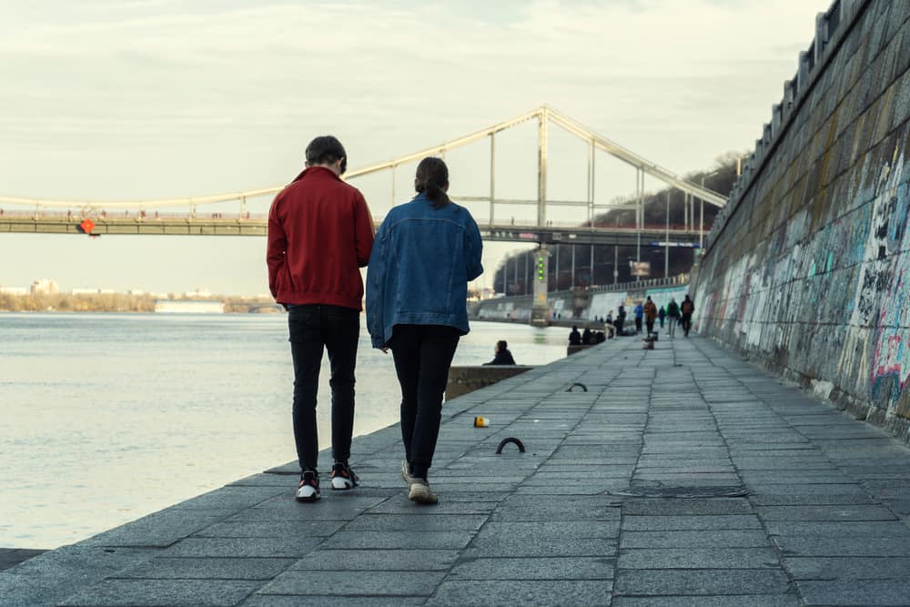 un homme et une femme marchent côte à côte dans la rue