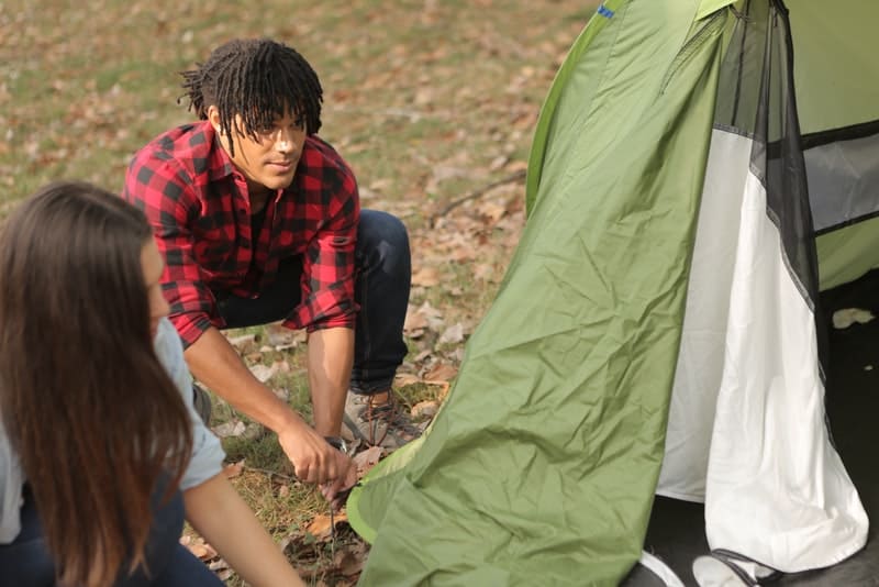 un homme et une femme ont installé une tente dans les bois