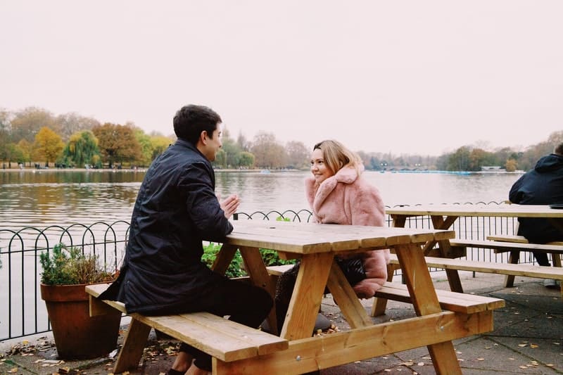 un homme et une femme parlent à table