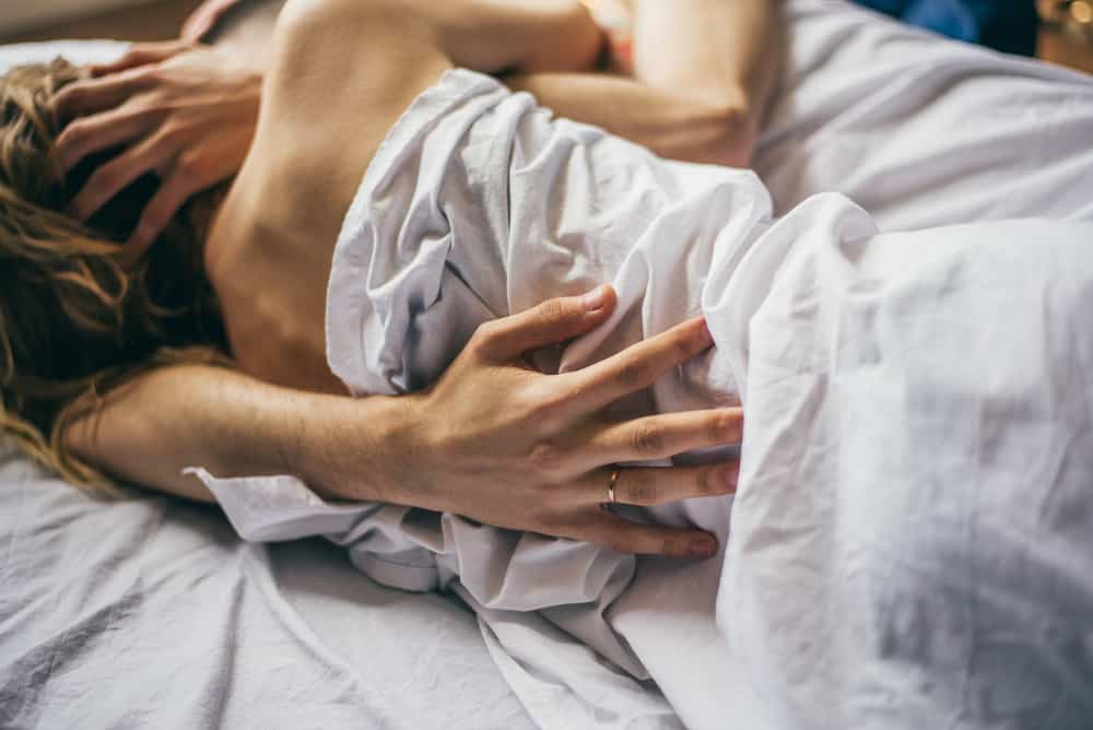 un homme et une femme se câlinent au lit