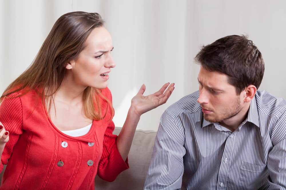 un homme et une femme se disputent elle lève les mains lui explique quelque chose