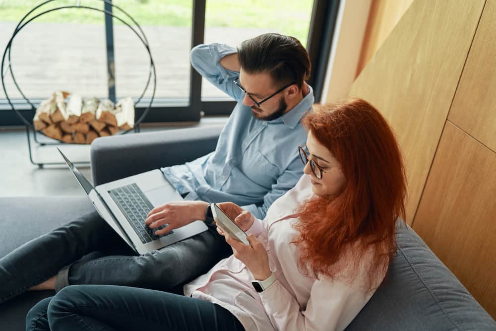 un homme et une femme sont assis derrière un ordinateur portable