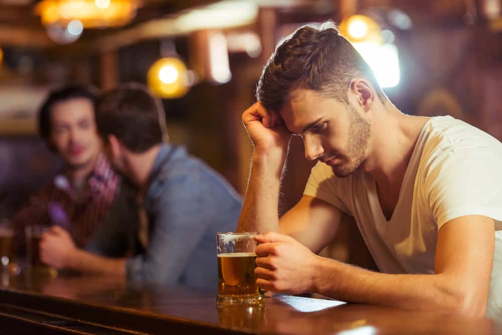 un homme imaginaire derrière un traîneau est assis et boit une bière