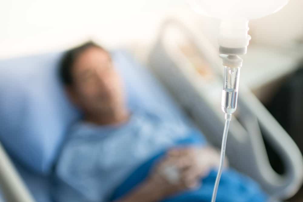 un homme malade dans un lit d'hôpital reçoit une perfusion