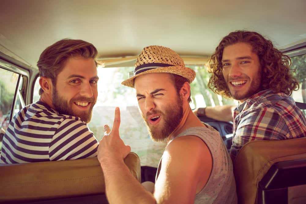 un homme prend une photo avec des amis dans la voiture