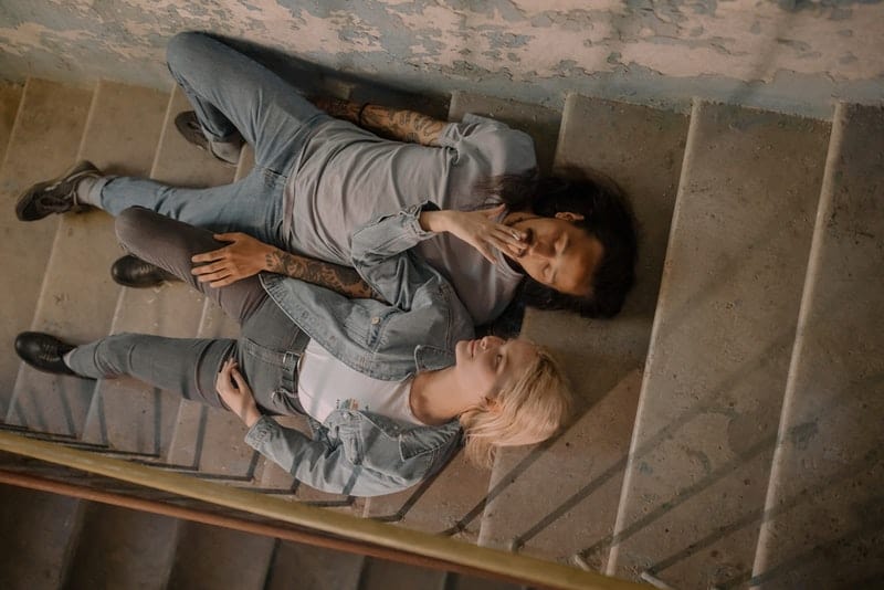 un jeune couple amoureux allongé sur les escaliers