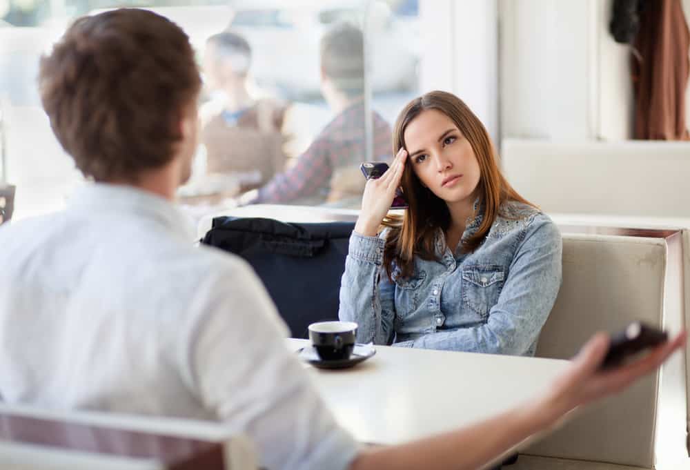 un jeune couple se disputant dans un café