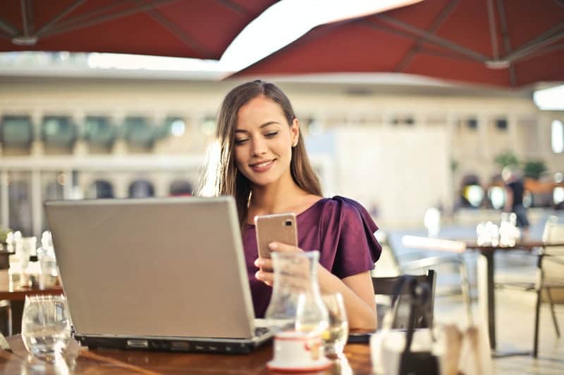 une femme assise dans un café et en appuyant sur un téléphone