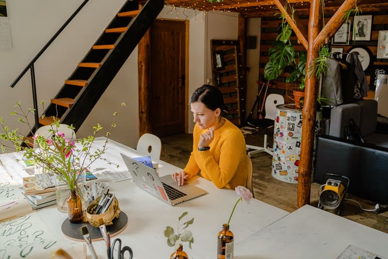 une femme assise à un bureau en tapant sur un ordinateur portable