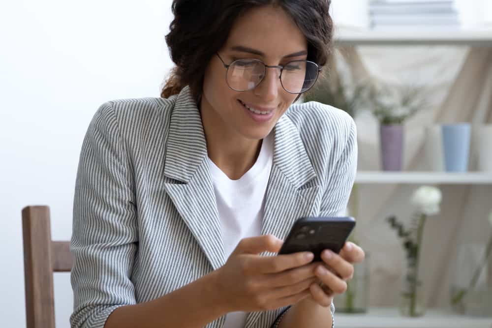 une femme au bureau écrit un sms