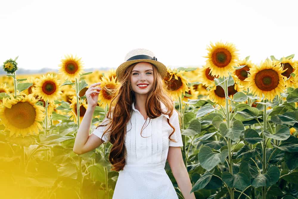 une femme avec un chapeau dans un champ de tournesol