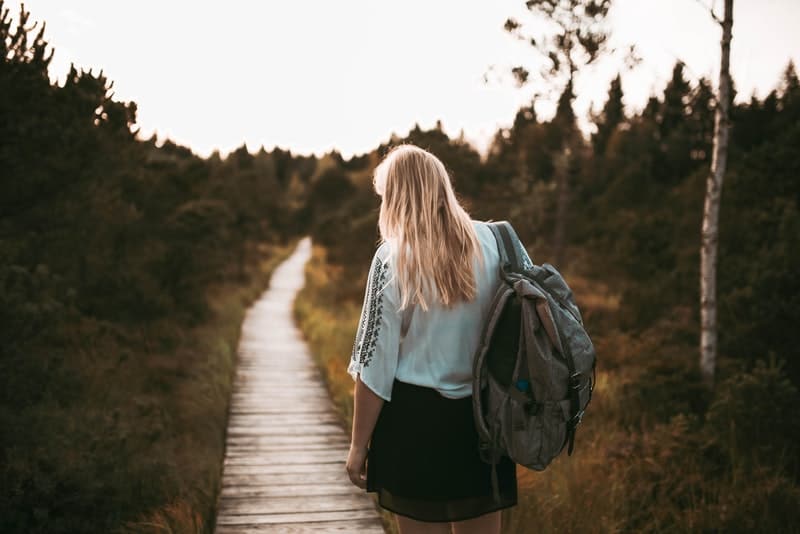 une femme avec un sac à dos se promène dans la nature