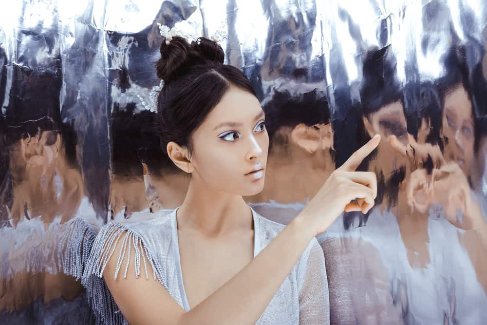 une femme avec une livre sur la tête se regarde dans le miroir