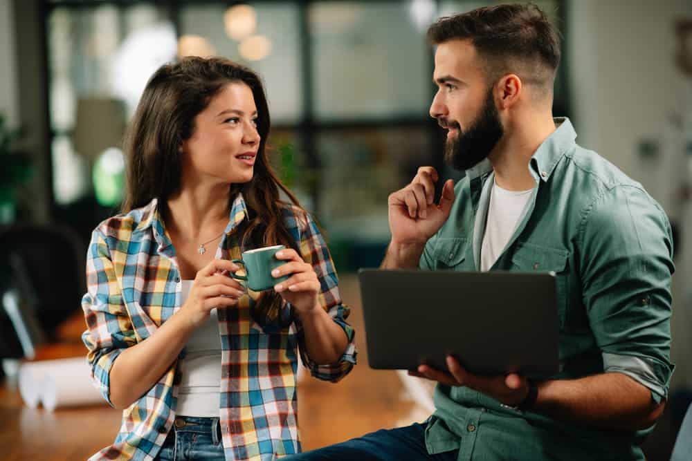 une femme avec une tasse de café est debout à côté d'un homme