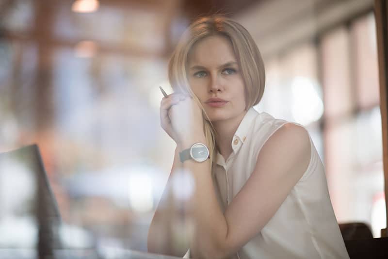 une femme blonde sérieuse regardant au loin