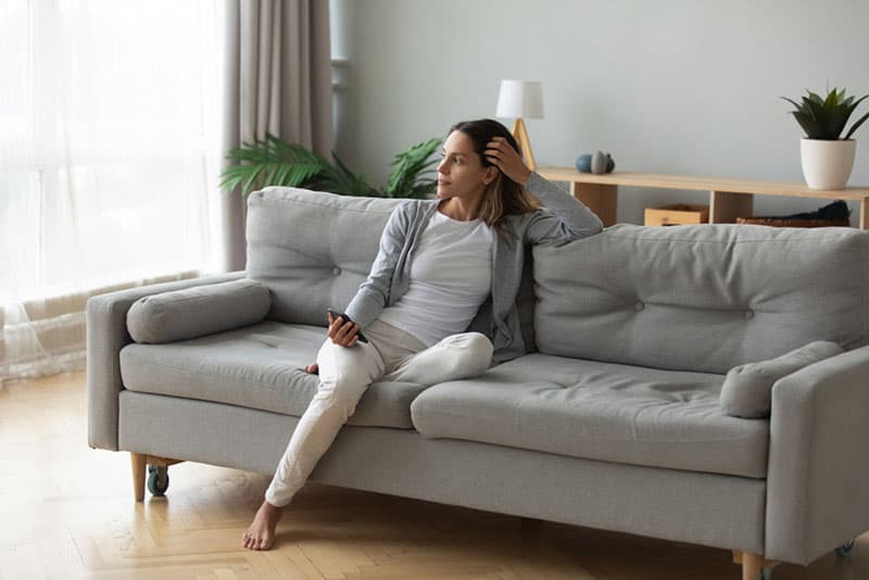 une femme calme et attentive assise sur le canapé