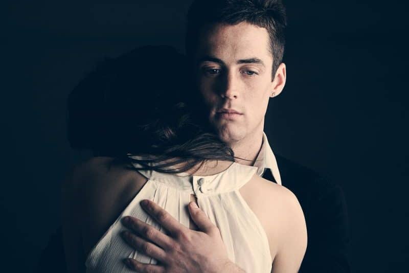 une femme dans les bras d'un homme sérieux