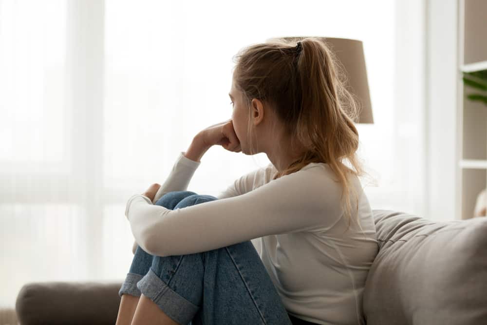 une femme déçue est assise sur le canapé