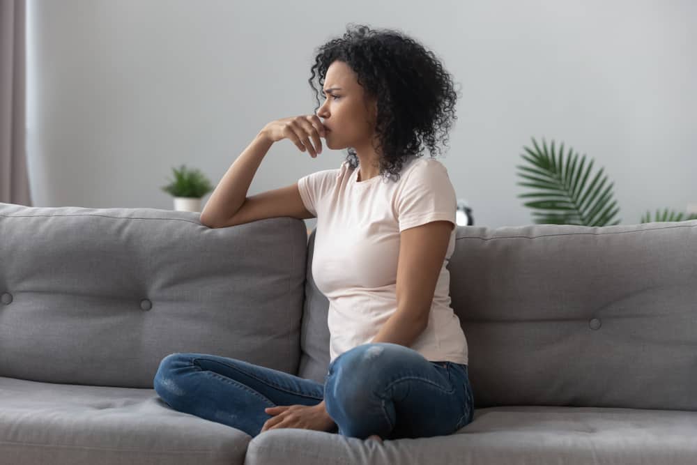 une femme déçue est assise sur le canapé
