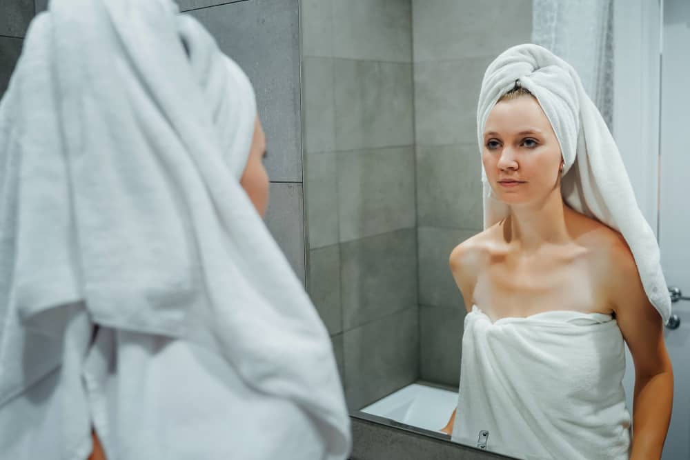 une femme déçue se regarde dans le miroir