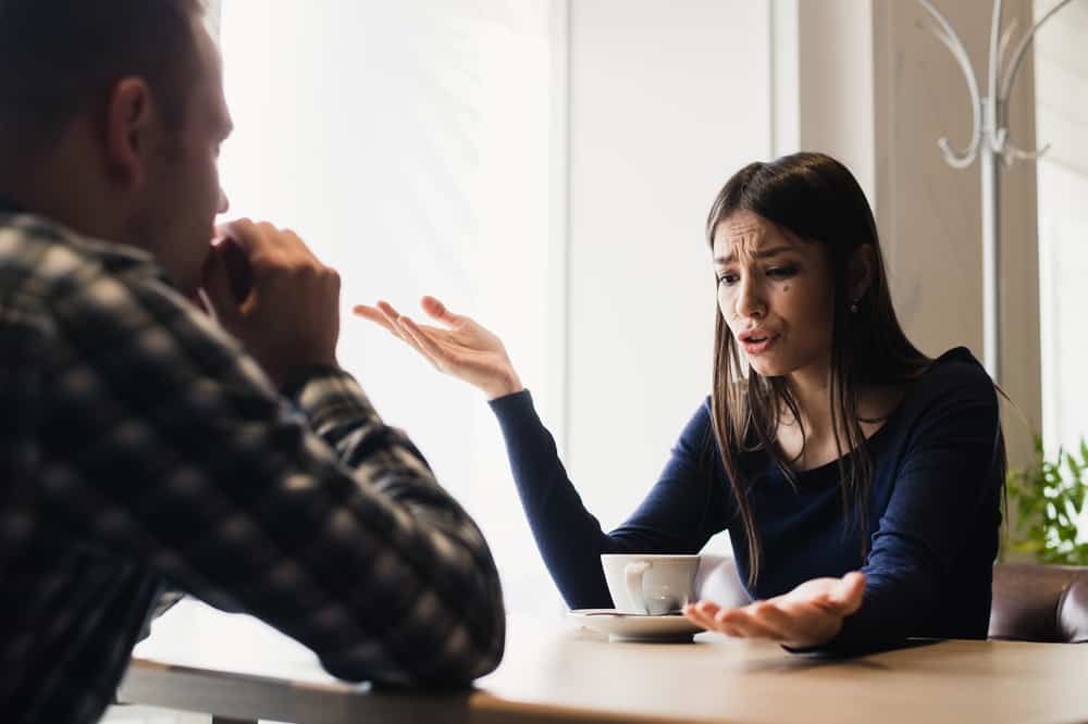une femme en colère buvant du café avec un homme