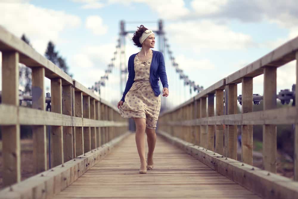 une femme en robe traverse le pont