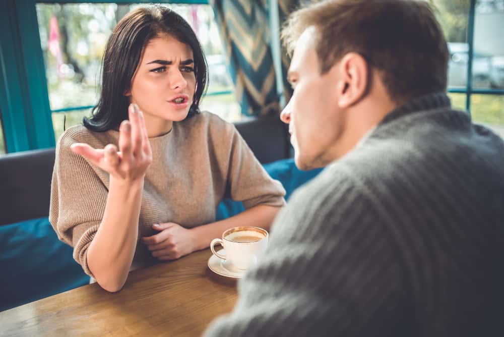 une femme et un homme se disputent dans un café