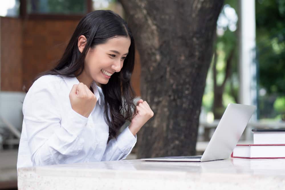 une femme heureuse à côté d'un ordinateur portable