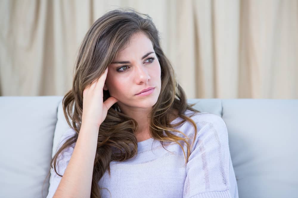 une femme inquiète s'assoit et pense
